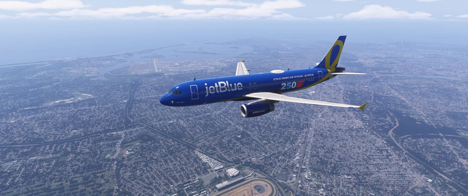 JetBlue A320 in the veterans' livery over New York, JFK behind